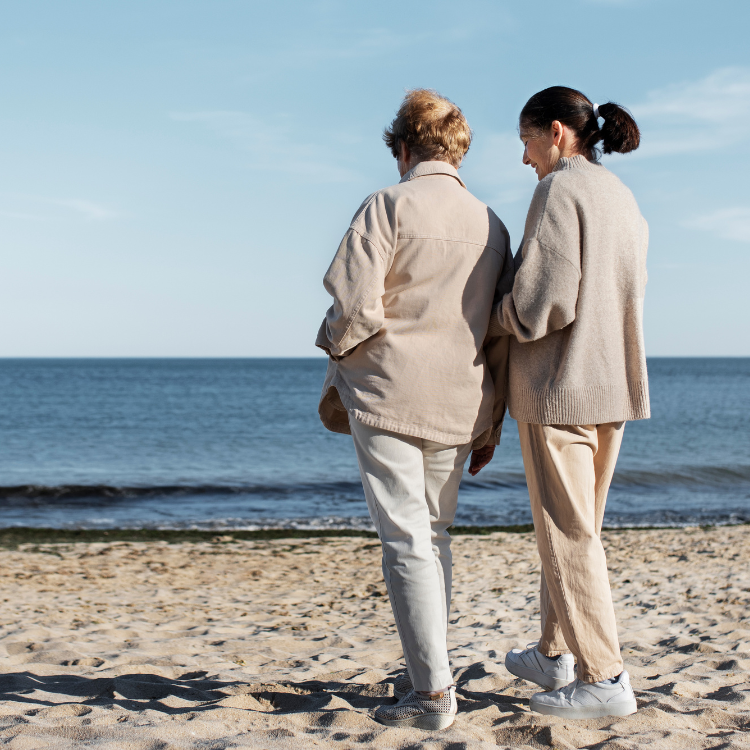 Senhora a levar uma pessoa idosa para a praia
